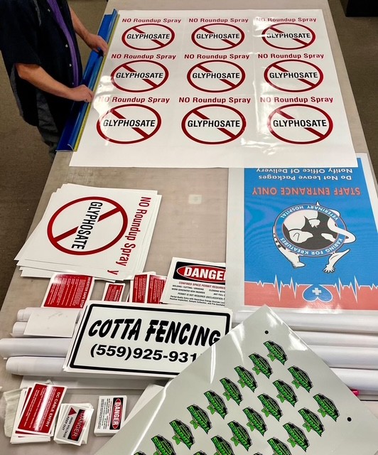 The Plain Insane Graphix work table filled with printed vinyl for signs and decals